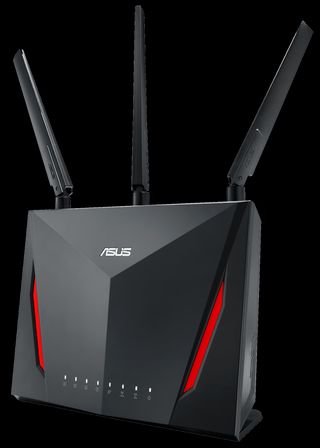 A futuristic black router with red stripes, 8 LEDs, 3 antennae and an âASUSâ logo sitting above a raised angled point on the front.